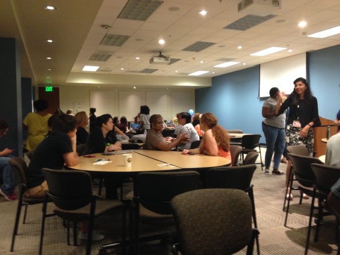 Twenty women in corporate conference room at round tables